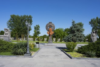 Park landscape with sculptures and plants under a blue sky, in the garden of the Yazidi Temple,