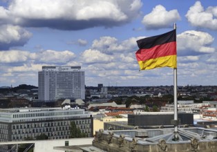 View from the Reichstag dome of a German flag in the wind with the Charité bed tower, Reichstag