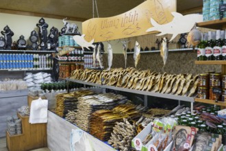 Various products and fish are arranged in a decorative market stall, fish sale, Tsovagyugh, Lake