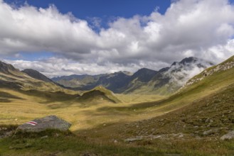 View from Passo del Sole in Alpe Carorescio with Piano Grande plateau and hiking trail marker,
