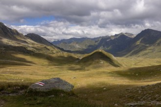 View from Passo del Sole in Alpe Carorescio with Piano Grande plateau and hiking trail marker,