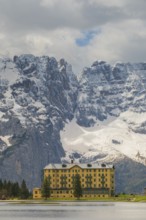 View over Lake Misurina to a building on the shore of the lake with a view towards the mountain