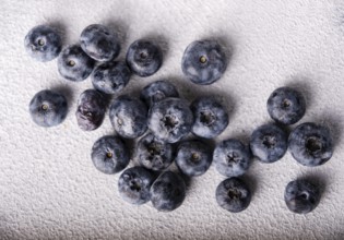Blueberries scattered on a light background, top view