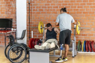 Man with prosthetic leg spotting another man with leg injuries or absence, who struggles with a