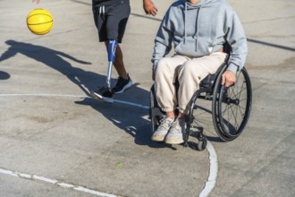 Two people with different physical disabilities staying active on an outdoor basketball court, one