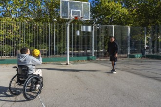Two young men with disabilities, one using a wheelchair and the other a prosthetic leg, enjoying a