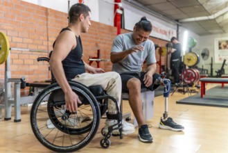 Two young men with disabilities one in a wheelchair, one with a prosthetic leg laughing and bonding