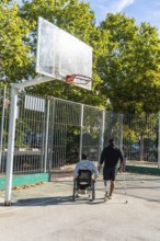 Disabled men on an outdoor basketball court, one in a wheelchair and another with a prosthetic leg
