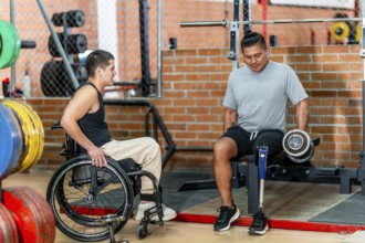 Two men with disabilities, one using a wheelchair and another with a prosthetic leg, engaging in