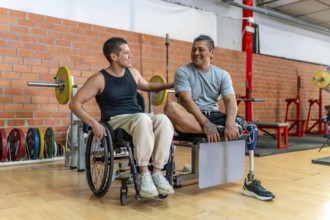 Two adaptive athletes, one in a wheelchair and one with a prosthetic leg, smiling and supporting