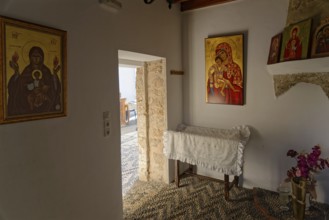 Room with religious icons of the Church of the Virgin Mary Tsambika (Kyra Psili), in warm lighting,