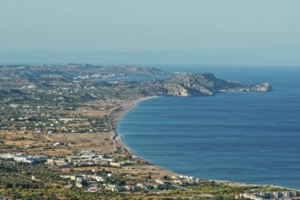 Wide coastline of Kolymbia with sandy beach and blue sea under a clear sky, Church of the Virgin