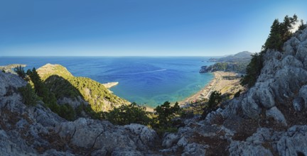 Panoramic view from the cliffs at Kyra Psili church to the sandy beach of Tsambika with deep blue