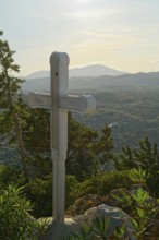 A wooden cross on a hill with a view of mountains and wooded landscape, Church of the Virgin Mary