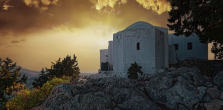 The white chapel of the Virgin Mary Tsambika (Kyra Psili) in front of a dramatic sunset sky with