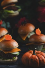 Small burgers with pumpkin in an autumnal, spooky atmosphere