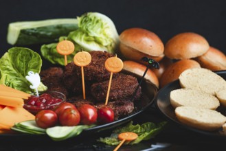 Burgers with Halloween decorations and colourful ingredients such as lettuce and tomatoes