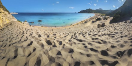 Picturesque Tsambika beach with sandy dunes, clear blue sea and rocks under a blue sky, Tsambika