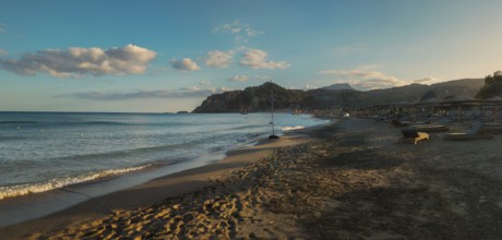 Sunset at Tsambika beach with calm sea, mountains in the background and a peaceful sky, Tsambika