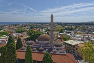 A panoramic view with minaret and domes in front of a cityscape of Rhodes and the sea in the