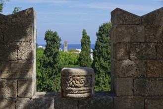 View from a stone wall with battlements of green trees and the distant sea under a blue sky, Grand