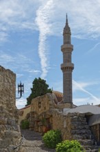 A minaret with a blue sky and ancient walls in a tranquil, historic setting, Suleiman Mosque,