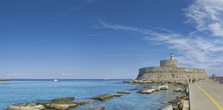 Fort of Saint Nikolaos stretches along the coast in the bright sunshine, Mandraki harbour, Medieval