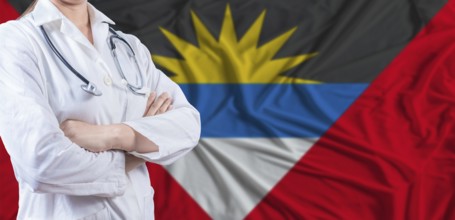 Doctor with crossed arms on Antigua and Barbuda flag. Antigua and Barbuda health and care concept.