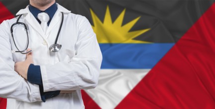 Male doctor with stethoscope on Antigua and Barbuda flag. Doctor holding stethoscope on Antigua and