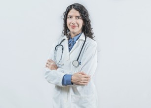 Portrait of smiling latin female doctor with crossed arms on isolated background. Success young