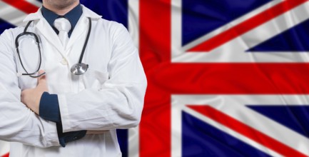 Male doctor with stethoscope on United Kingdom flag. Doctor holding stethoscope on United Kingdom