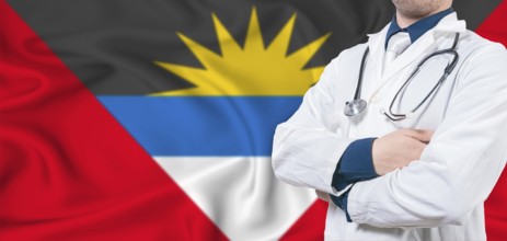 Antigua and Barbuda healthcare concept. Male doctor on Antigua and Barbuda flag. Doctor with