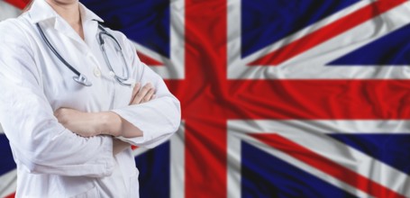 Doctor with crossed arms on United Kingdom flag. United Kingdom health and care concept. Female