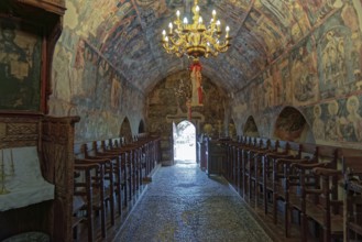 Historic church interior with paintings and a decorative chandelier, conveying a calm and venerable