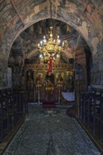 Magnificently decorated church interior with frescoes and a large candlestick that creates a