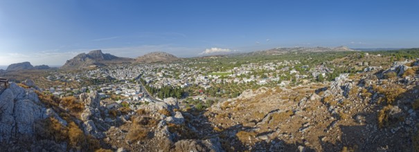 Panoramic view of the town of Archangelos in the middle of a vast and sunny mountain landscape,