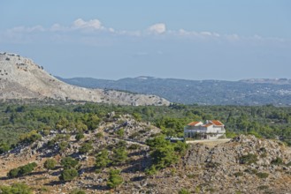 Single house on a rocky hill in the middle of a barren and lush landscape, Archangelos, Rhodes