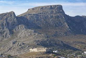 Rocky mountain landscape with the castle ruins of Archangelos under a light blue sky, Archangelos,