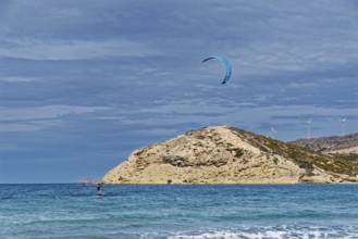 Prasonisi beach with a view of the sea and rocky island with visible kite and wind turbines. Windy