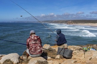 Anglers on the cliffs at the viewpoint above Praia da Bordeira beach, near Carrapateira, popular