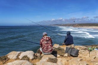 Anglers on the cliffs at the viewpoint above Praia da Bordeira beach, near Carrapateira, popular