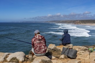 Anglers on the cliffs at the viewpoint above Praia da Bordeira beach, near Carrapateira, popular