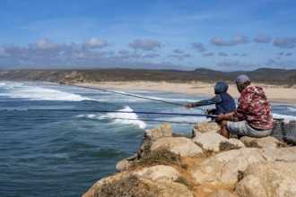 Anglers on the cliffs at the viewpoint above Praia da Bordeira beach, near Carrapateira, popular