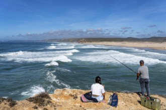 Anglers on the cliffs at the viewpoint above Praia da Bordeira beach, near Carrapateira, popular