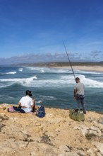 Anglers on the cliffs at the viewpoint above Praia da Bordeira beach, near Carrapateira, popular