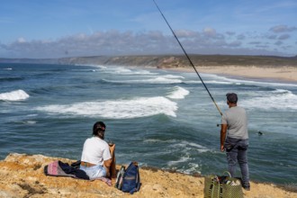 Anglers on the cliffs at the viewpoint above Praia da Bordeira beach, near Carrapateira, popular
