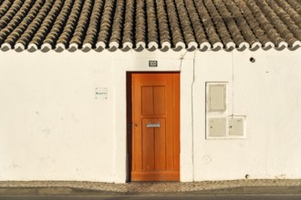 House with orange door, old building in the historic centre of Tavira, Algarve, Portugal