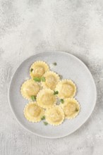 Fresh, ravioli with cheese, and microgreens, on a light plate, top view, no people