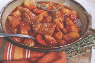 Meat goulash with potatoes and carrots, sweet peppers, in a saucepan, top view, traditional