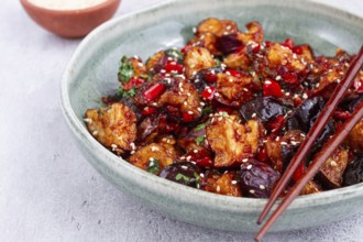 Fried eggplant, Chinese style, in sweet and sour sauce, with pepper and sesame seeds, in a green